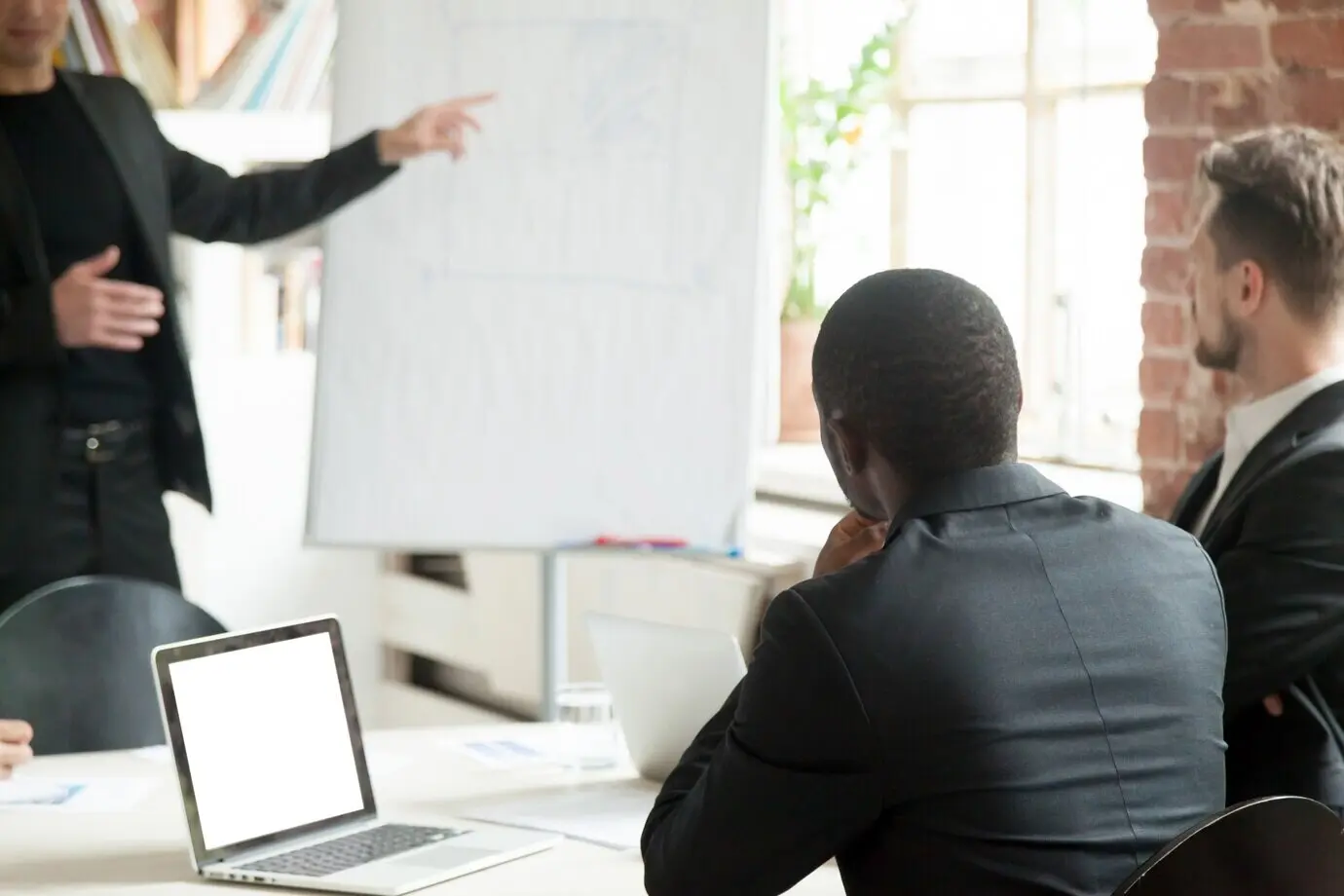 Команда бизнесменов слушает лекцию по бизнесу во время брифинга.