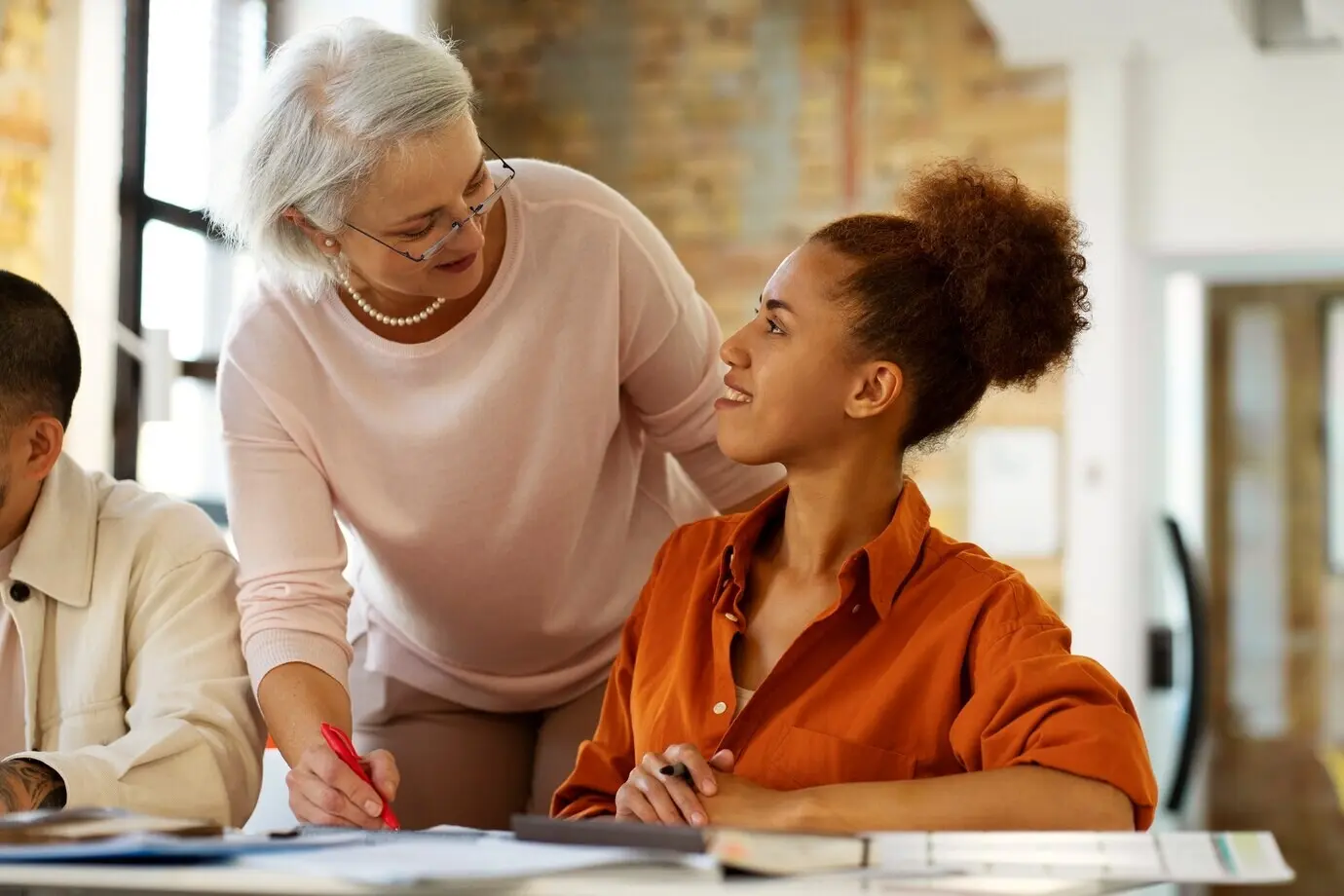 Вид спереди: молодая женщина и пожилая женщина разговаривают.